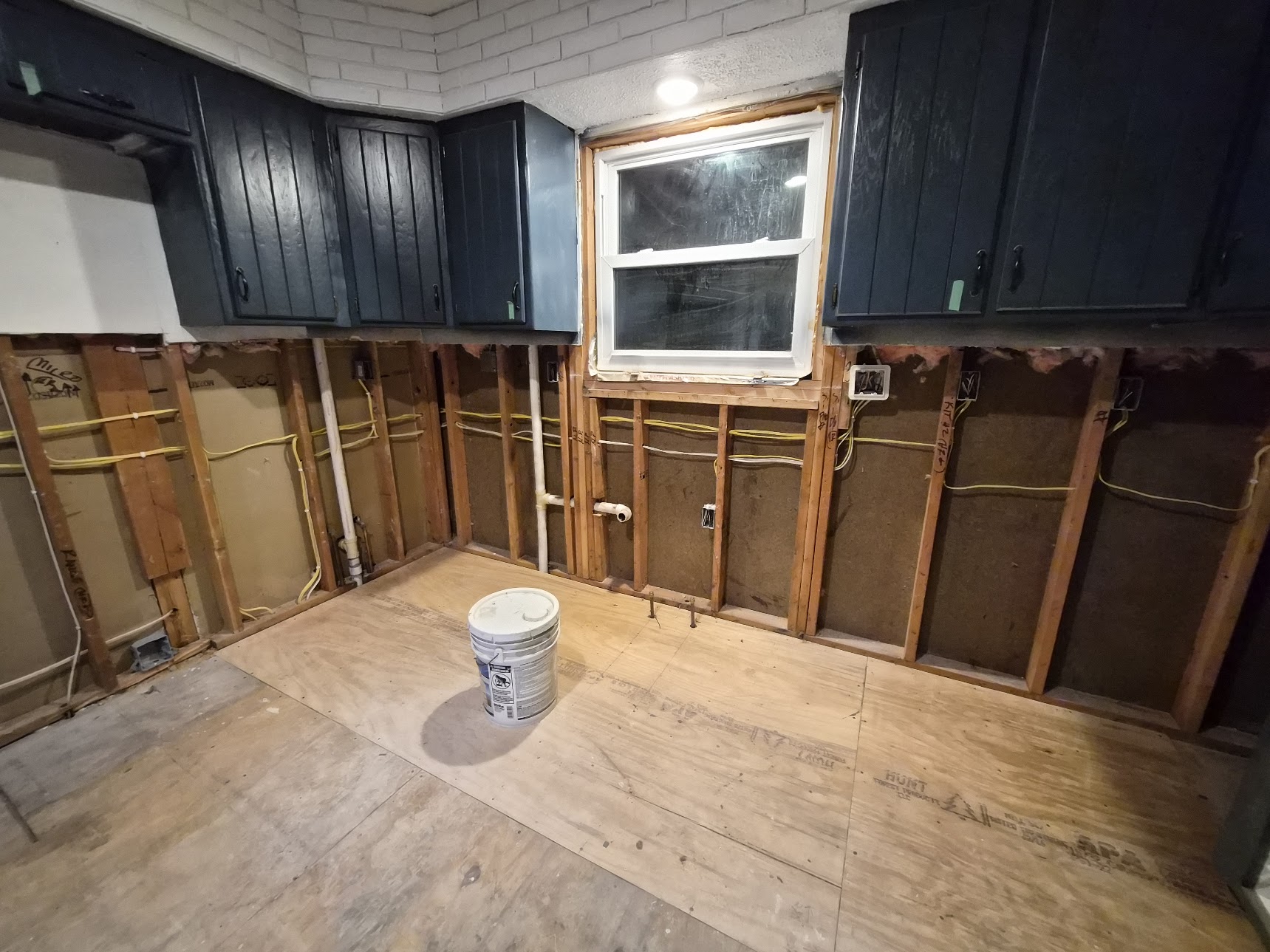 Kitchen remodel with exposed wall wiring and ceiling openings for recessed lights